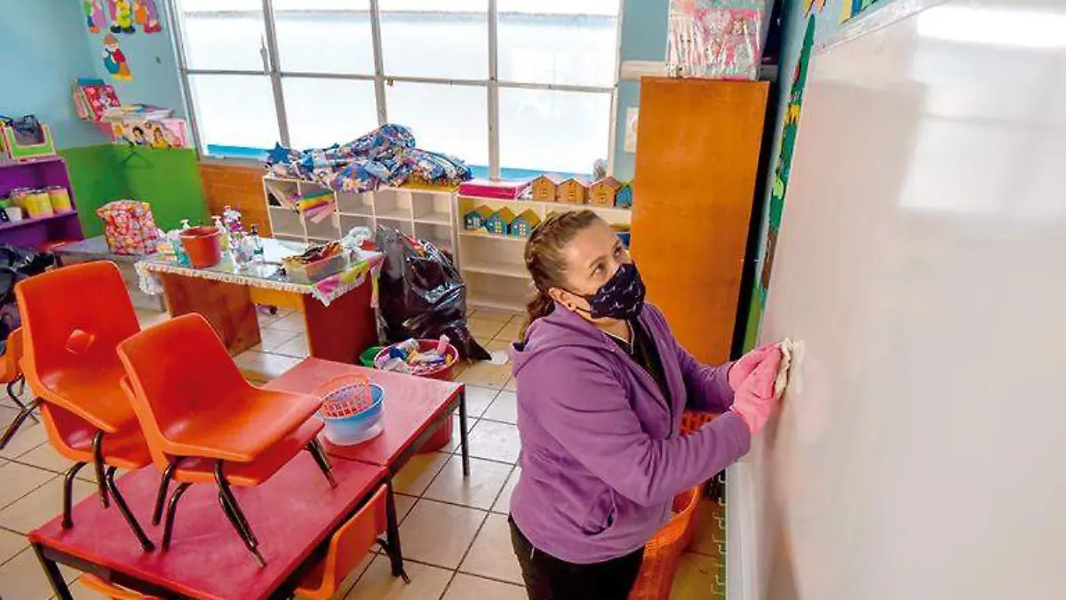 Mujer realiza limpieza en un salón de clases